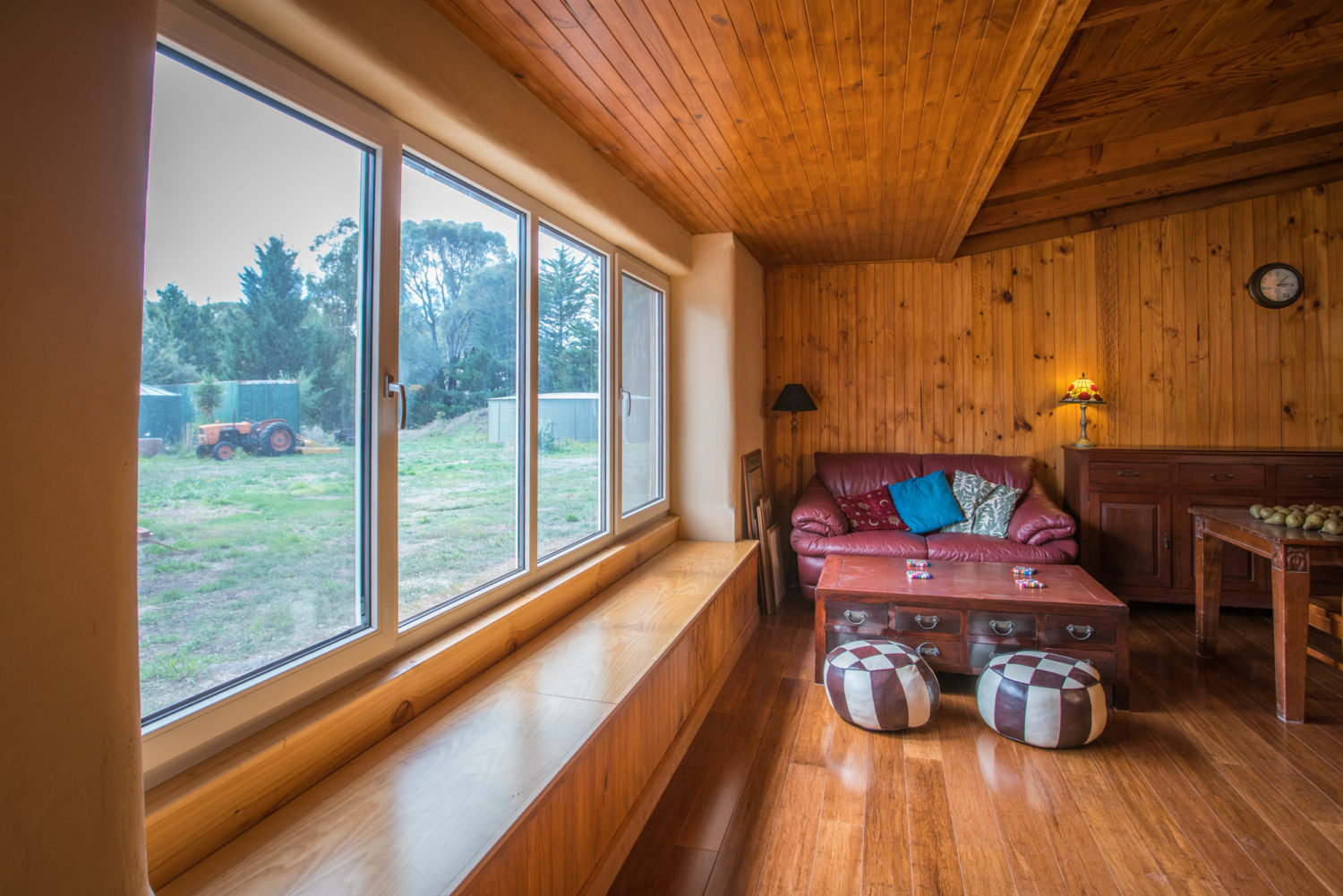 Cosy wooden room with a red couch.