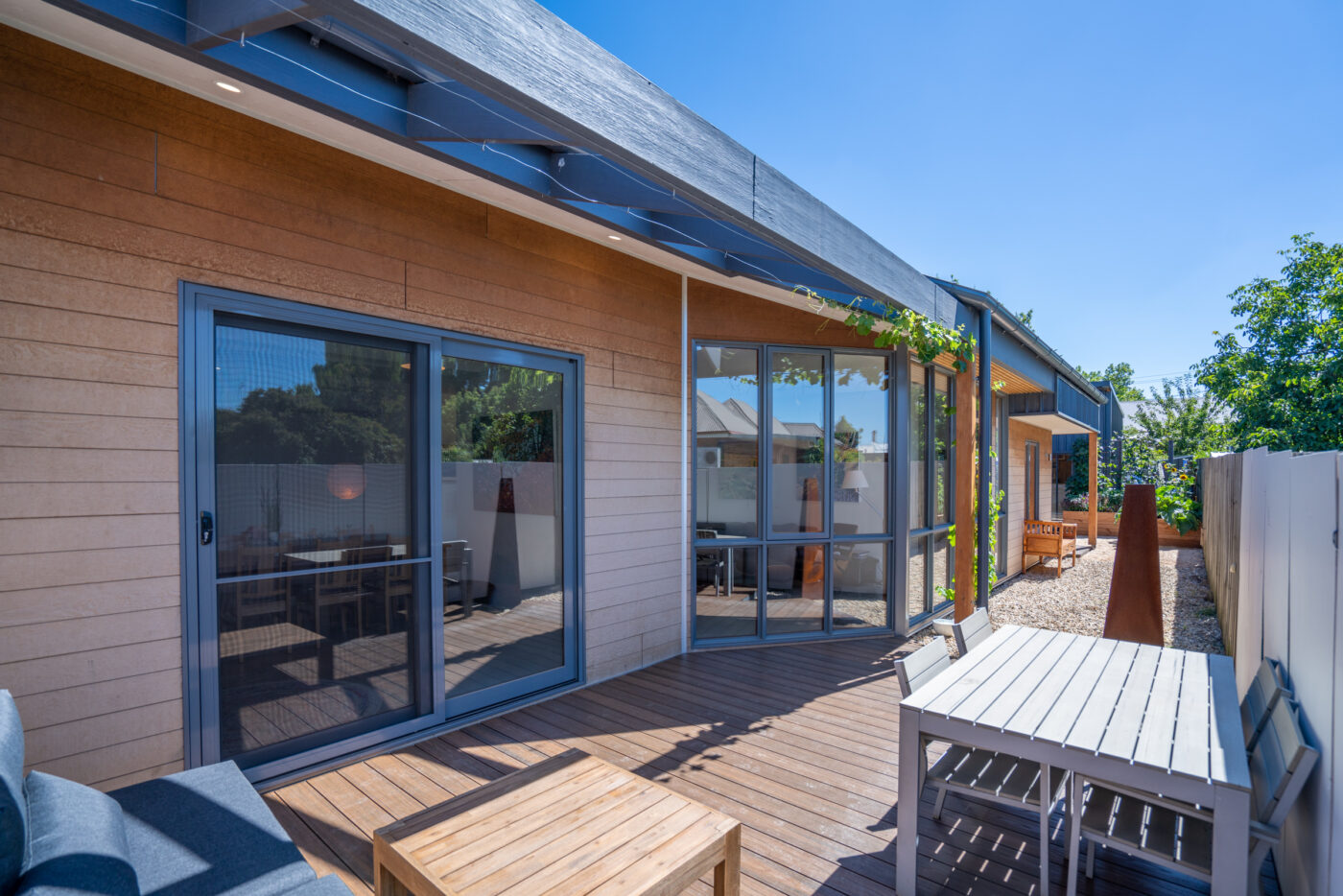Modern deck with outdoor furniture and garden view.