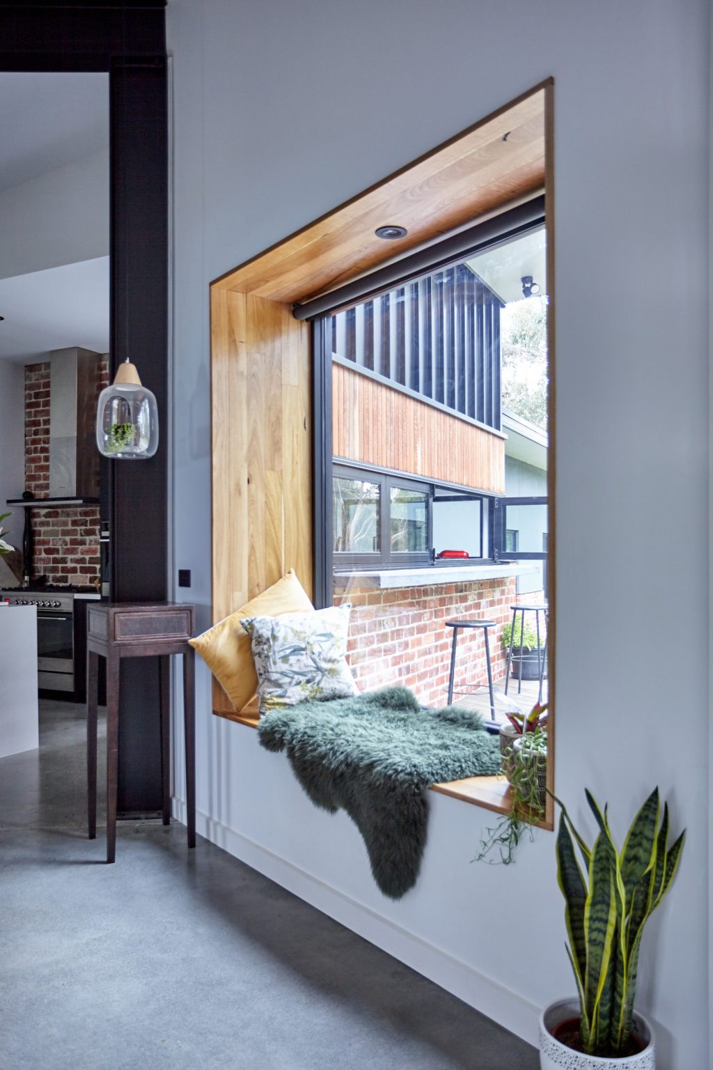 Modern window nook with plants and pillows